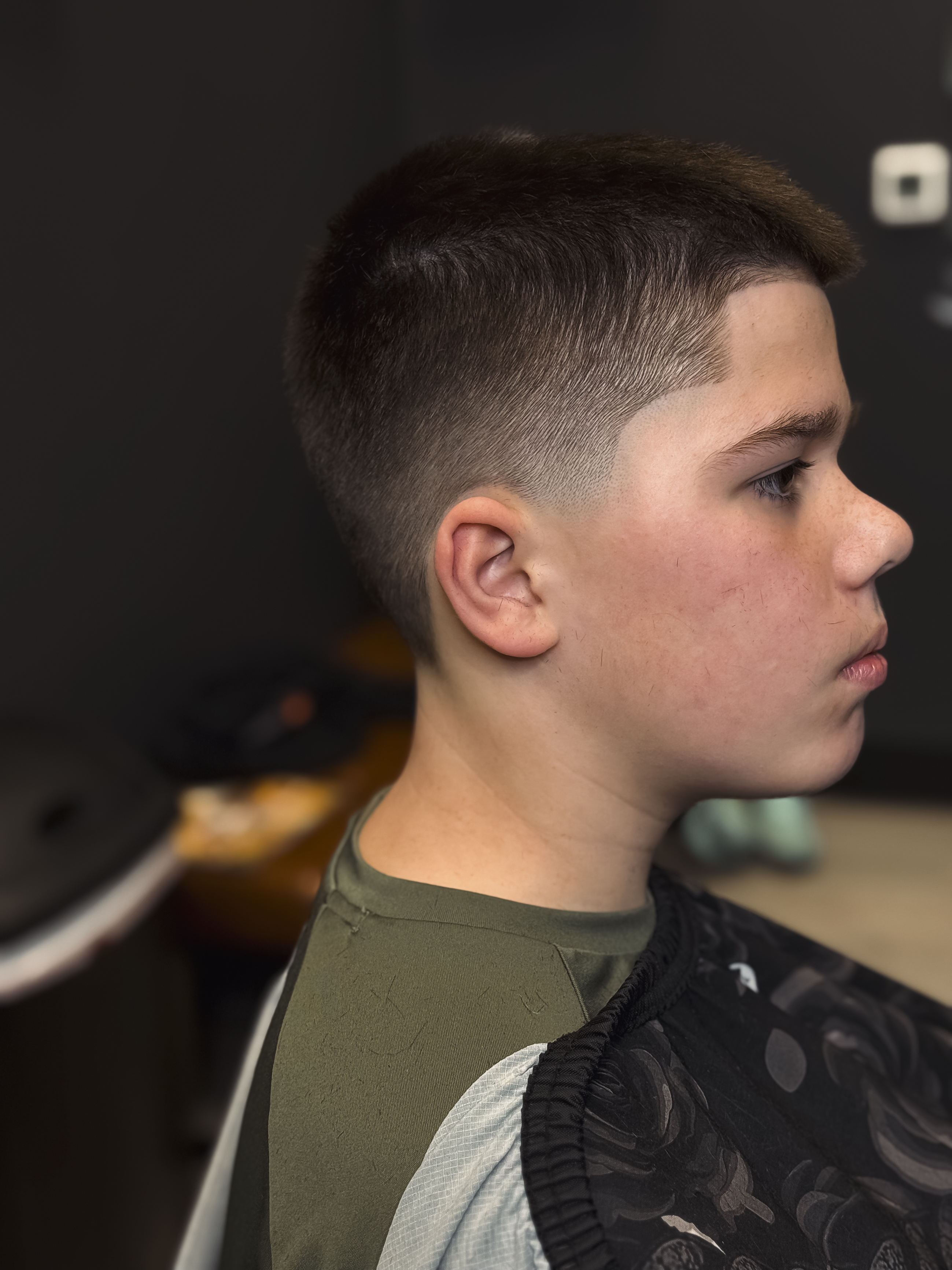 Clean youth fade and sharp natural lineup by DNA Barbershop